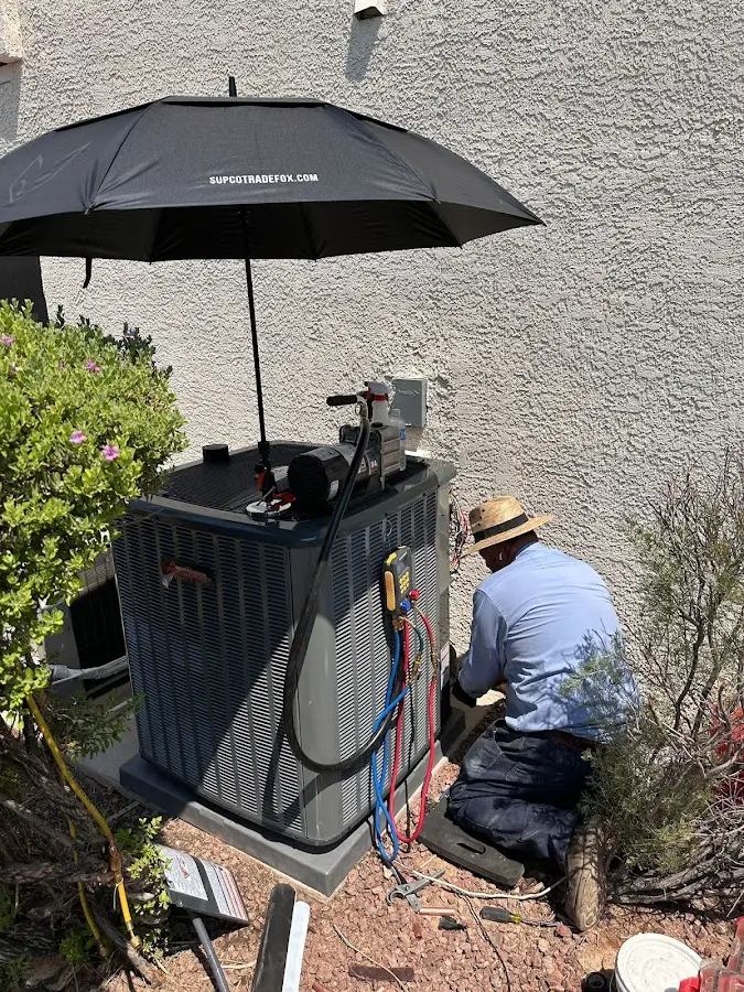 HVAC technician performing outdoor AC maintenance in Colchester